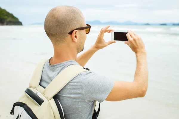 Handsome young  man taking photo with cell phone — Stock Photo, Image