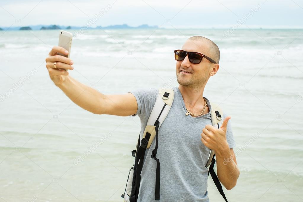 Handsome young man taking selfie with cell phone