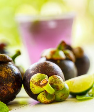 Beyaz bir tablo üzerinde mangosten ile nane yaprakları