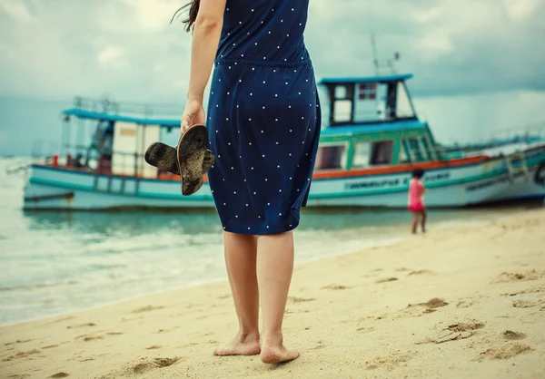 Femme debout sur la plage et tenant dans sa main la fessée — Photo