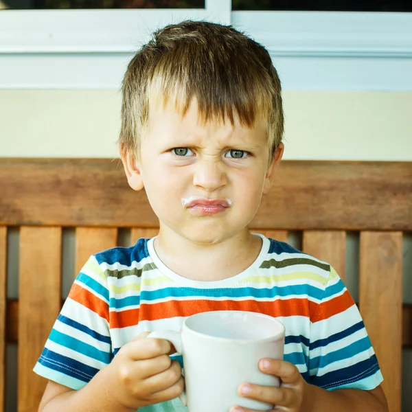 Enojado niño bebiendo leche — Foto de Stock