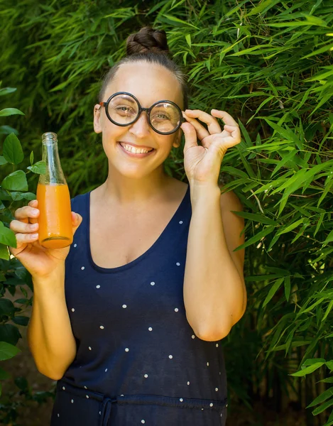 Nörd tjej med en flaska juice — Stockfoto