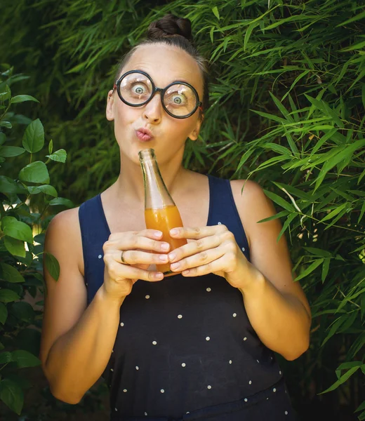 Chica nerd con una botella de jugo — Foto de Stock