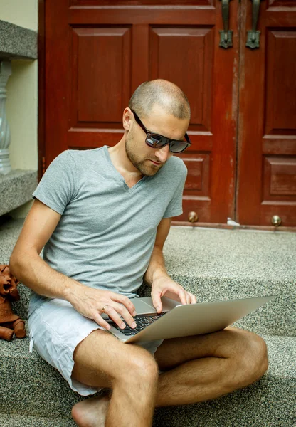 Um homem trabalhando em um computador na natureza — Fotografia de Stock