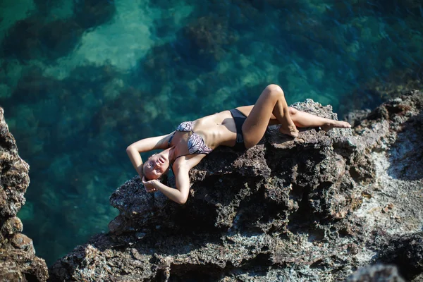 Girl lying on coastal sea rocks. Well being healthy lifestyle — Stock Photo, Image
