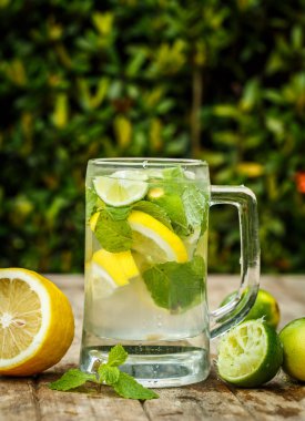 Su ile limon, limon ve nane bir ahşap tahta üzerinde