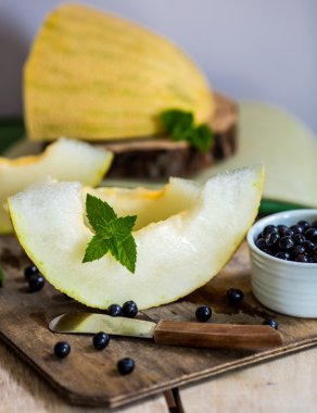 taze kavun ve yaban mersini bir ahşap kesme tahtası üzerinde. Seçici