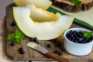 taze kavun ve yaban mersini bir ahşap kesme tahtası üzerinde. Seçici