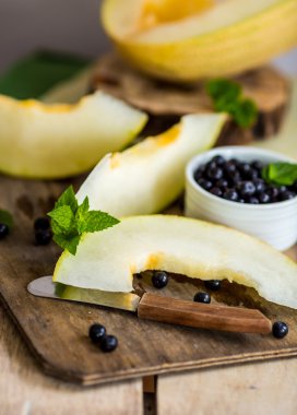 taze kavun ve yaban mersini bir ahşap kesme tahtası üzerinde. Seçici
