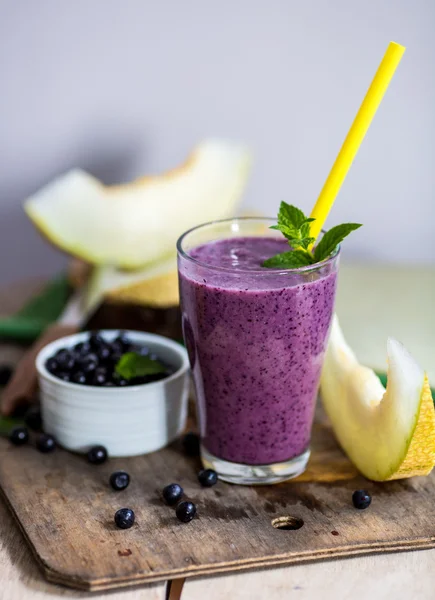 Smoothie aux myrtilles dans un verre avec une paille et un brin de menthe, ov — Photo