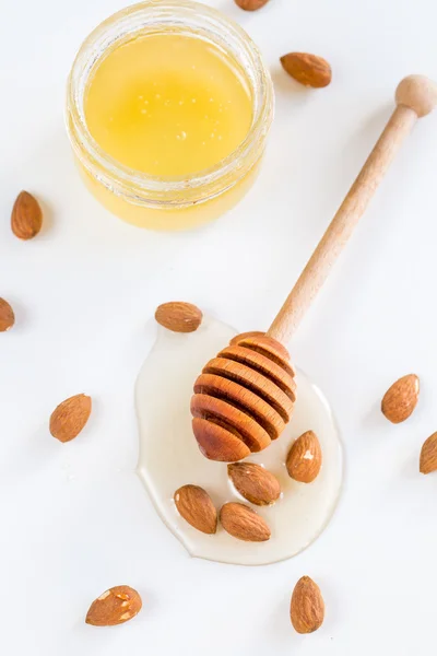 Nueces de almendras con miel sobre blanco. Componente en la cocina —  Fotos de Stock