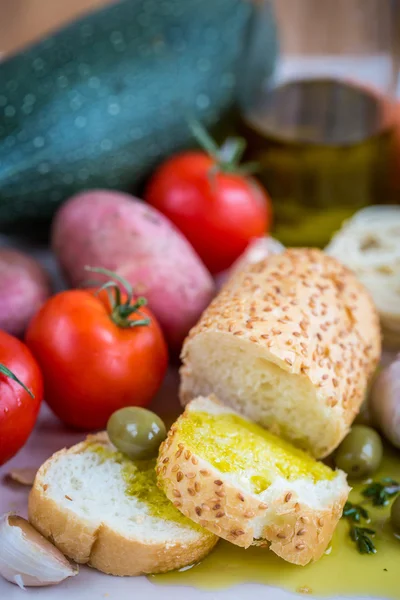 Extra szűz olívaolaj, fehér baguette és zöldségek — Stock Fotó