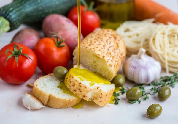 Extra szűz olívaolaj, fehér baguette és zöldségek — Stock Fotó