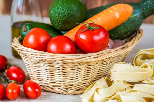 Samenstelling met ruwe pasta's, fruit en olijfolie — Stockfoto