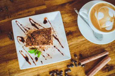 Cappuccino with tiramisu on wooden table