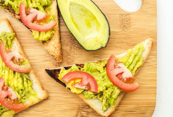 Sandwich vegan dengan alpukat dan tomat di papan potong — Stok Foto