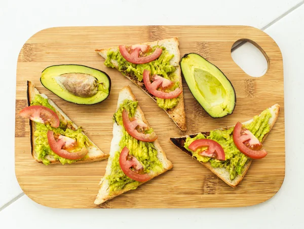 Sanduíche Vegan com abacate e tomate na tábua de corte — Fotografia de Stock