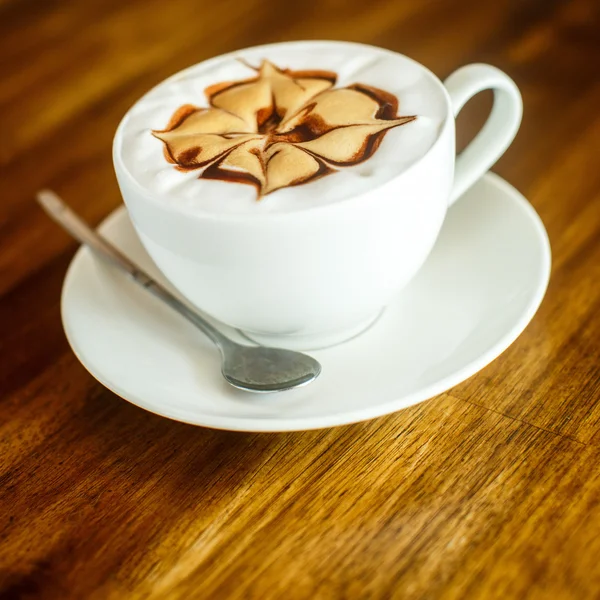 Cappuccino em um fundo marrom — Fotografia de Stock