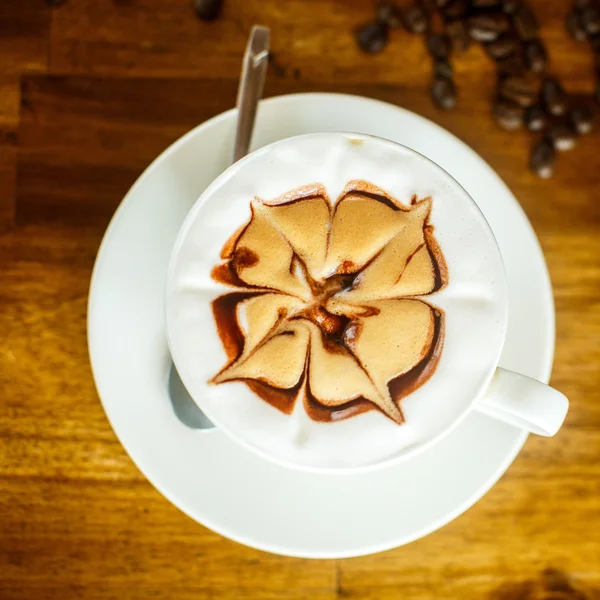Cappuccino aux grains de café frais sur fond brun — Photo