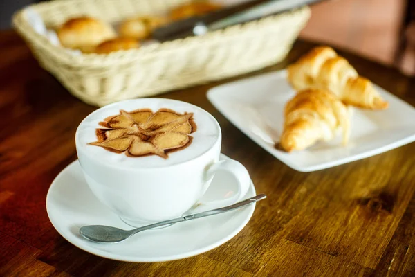 Cappuccino et croissants sur fond brun — Photo