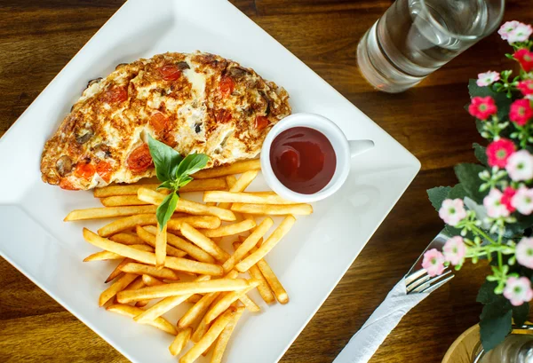 Ovos mexidos e batatas fritas em uma mesa de madeira — Fotografia de Stock