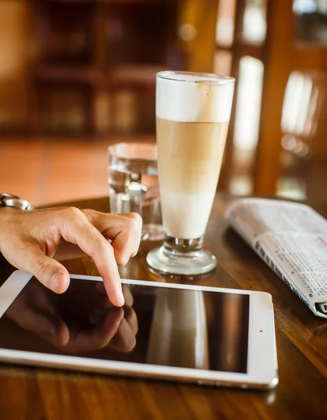 Hands of a man with blank tablet device over a wooden workspace — Φωτογραφία Αρχείου