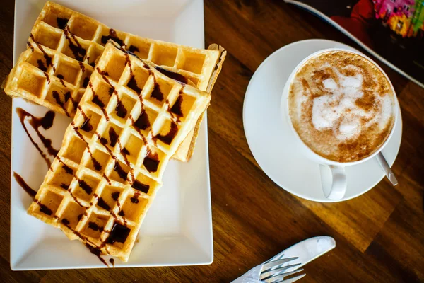 Waffeln mit Schokolade und Kaffee auf dem Holztisch — Stockfoto