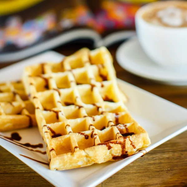 Waffles with chocolate and coffee on the wooden table — Stock Photo, Image