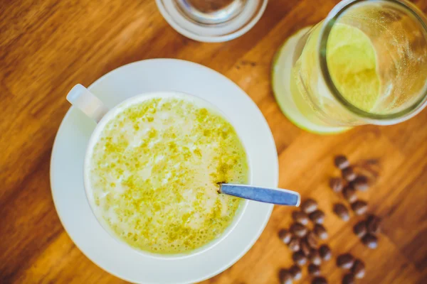 Hot matcha green tea cappuccino on wooden table — Stock fotografie