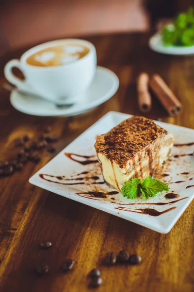 Cappuccino with tiramisu on wooden table — Stock Fotó