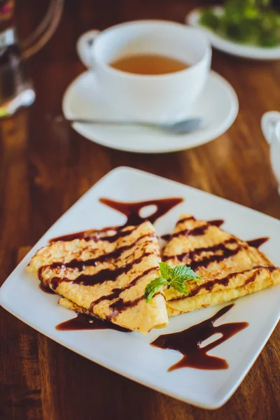 Pancakes with chocolate sauce and tea — Stockfoto