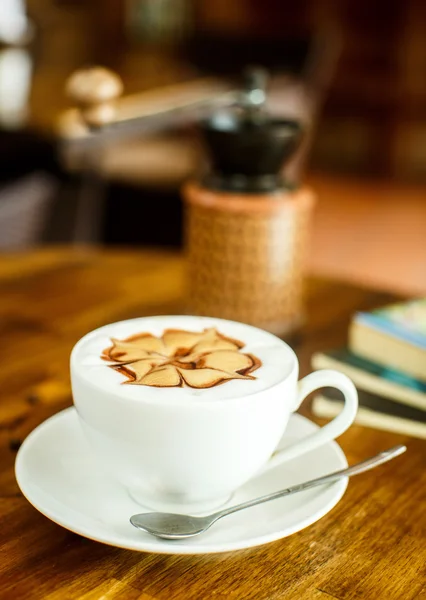 Cappuccino com grãos de café frescos, água e livros em um b marrom — Fotografia de Stock