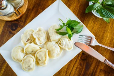 Ahşap bir masa üzerinde ekşi kremalı köfte