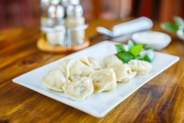 Ahşap bir masa üzerinde ekşi kremalı köfte