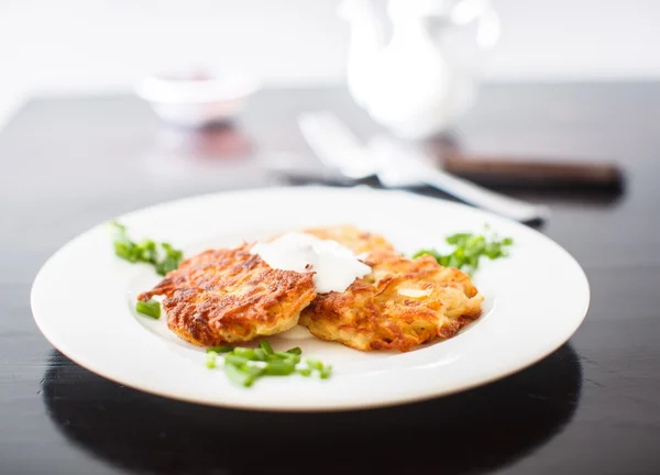 Potato pancakes with sour cream and green onions — Stock Photo, Image