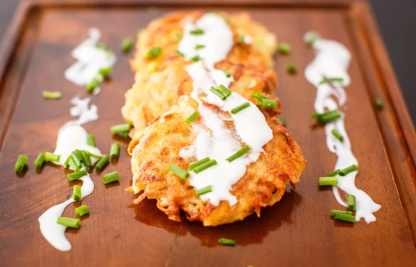 Fried potato pancakes with sour cream and green onions — Stock Photo, Image