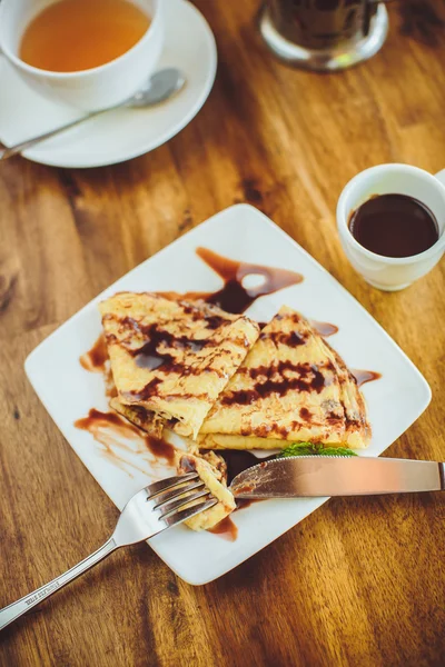 Pancakes with chocolate sauce and green tea — Stock Photo, Image