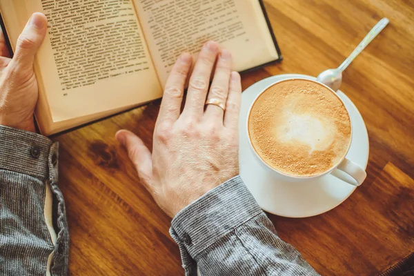 Erkek el, kahve ve kitap masada — Stok fotoğraf
