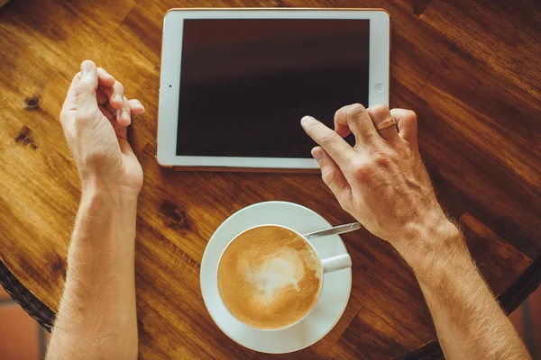Men's hands hold the tablet with coffee — Stock Photo, Image