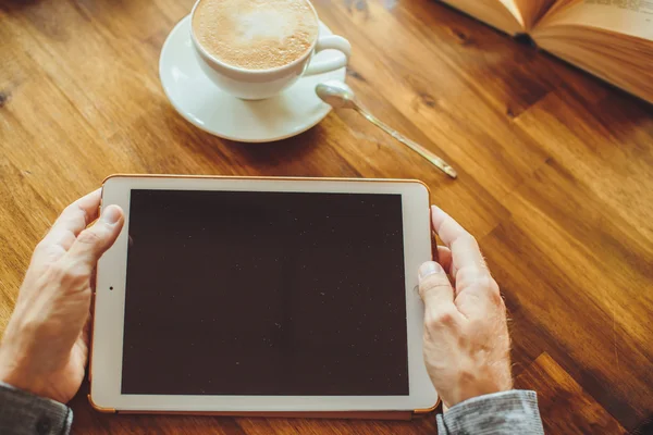 Men's hands hold the tablet with coffee — Stock Photo, Image