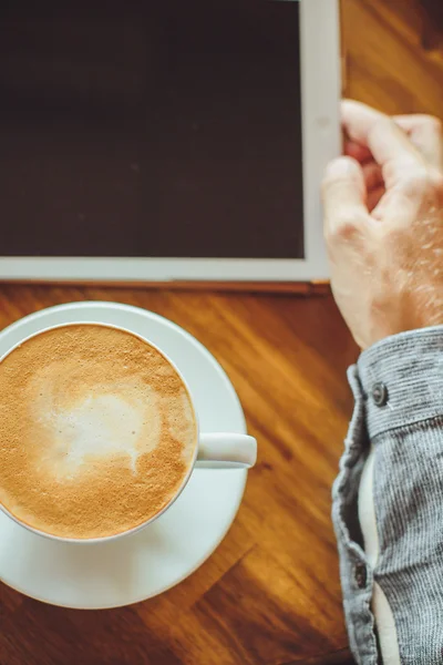 Men's hands hold the tablet with coffee — Stock Photo, Image