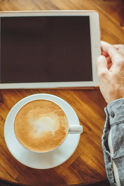 Mãos masculinas segurar o tablet com café — Fotografia de Stock