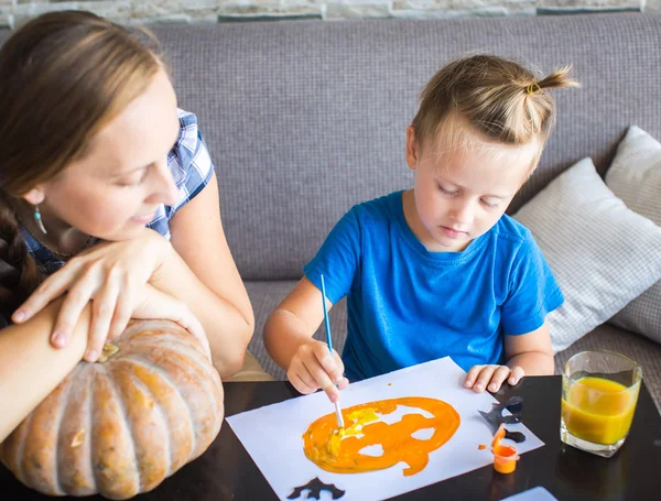 Mom with son draw a pumpkin for Halloween — Stock Photo, Image