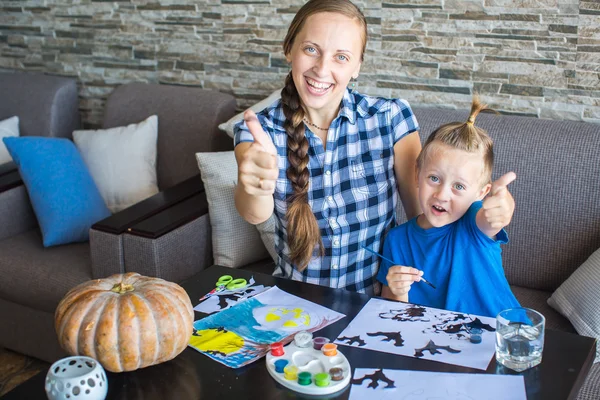 Mom with son draw a pumpkin for Halloween — Stock Photo, Image