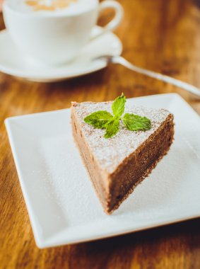 Bir kapuçino bir restaura ahşap bir tablo ile çikolatalı kek