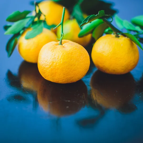 Mandarinas con hojas sobre una mesa de madera. — Foto de Stock