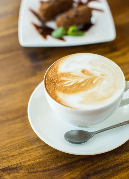 Chokladkaka kartoshka och cappuccino på ett träbord — Stockfoto