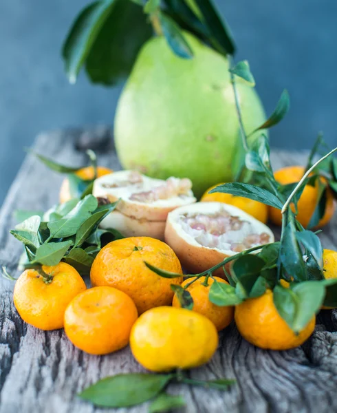 Pomelo, romã e tangerina em uma mesa de madeira — Fotografia de Stock