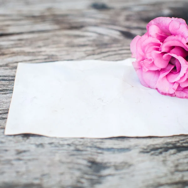 Lisianthus buquê em uma mesa de madeira com nota em branco — Fotografia de Stock