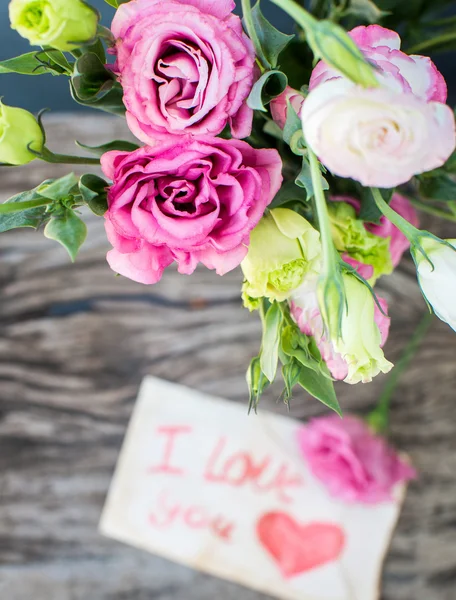 Lisianthus buquê em uma mesa de madeira com mensagem Eu te amo — Fotografia de Stock